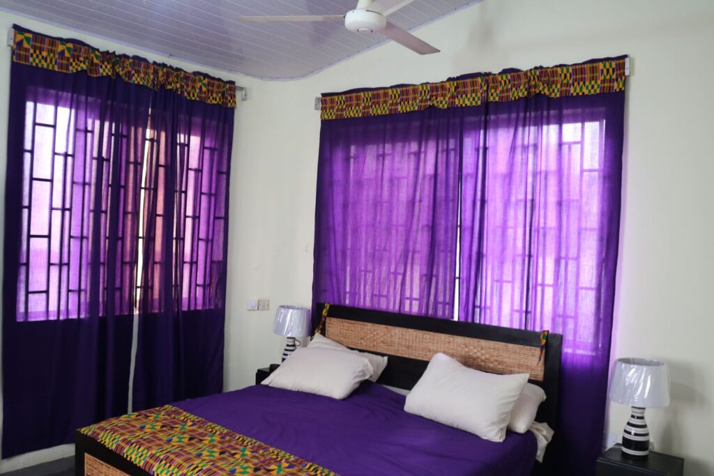 Sankofa guest house hotel airbnb deluxe ensuite ground king bedroom with wall shelves purple